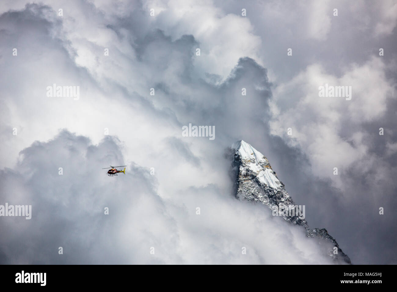Un Eurocopter battenti in condizioni pericolose a 15.000 ft nelle nuvole ma ancora al di sotto dei picchi di montagna sul suo modo al campo base di Mt. Everest. Il Nepal Foto Stock
