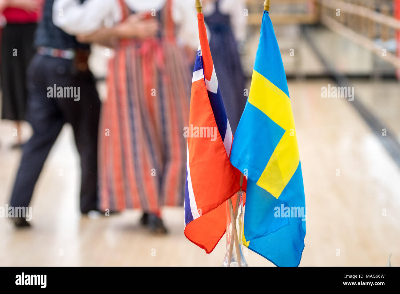 Scandinavi e bandiere Svedese stand centro mentre ballerini eseguono una tradizionale danza scandinavo in background Foto Stock