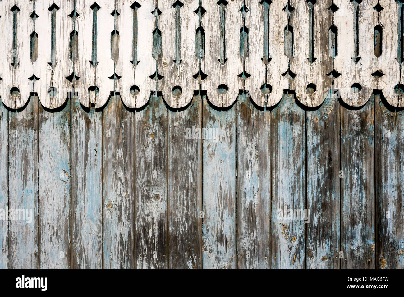 Weathered dipinto di blu peeling recinzione in legno e arrotondata scolpiti decor in legno sulla parte superiore. Foto Stock