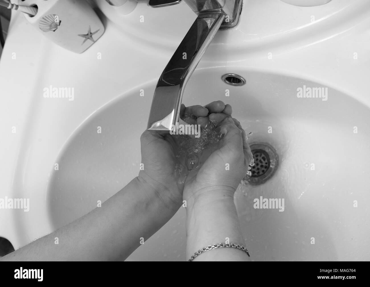 Foto in bianco e nero di lavaggio delle mani in bagno. Foto Stock