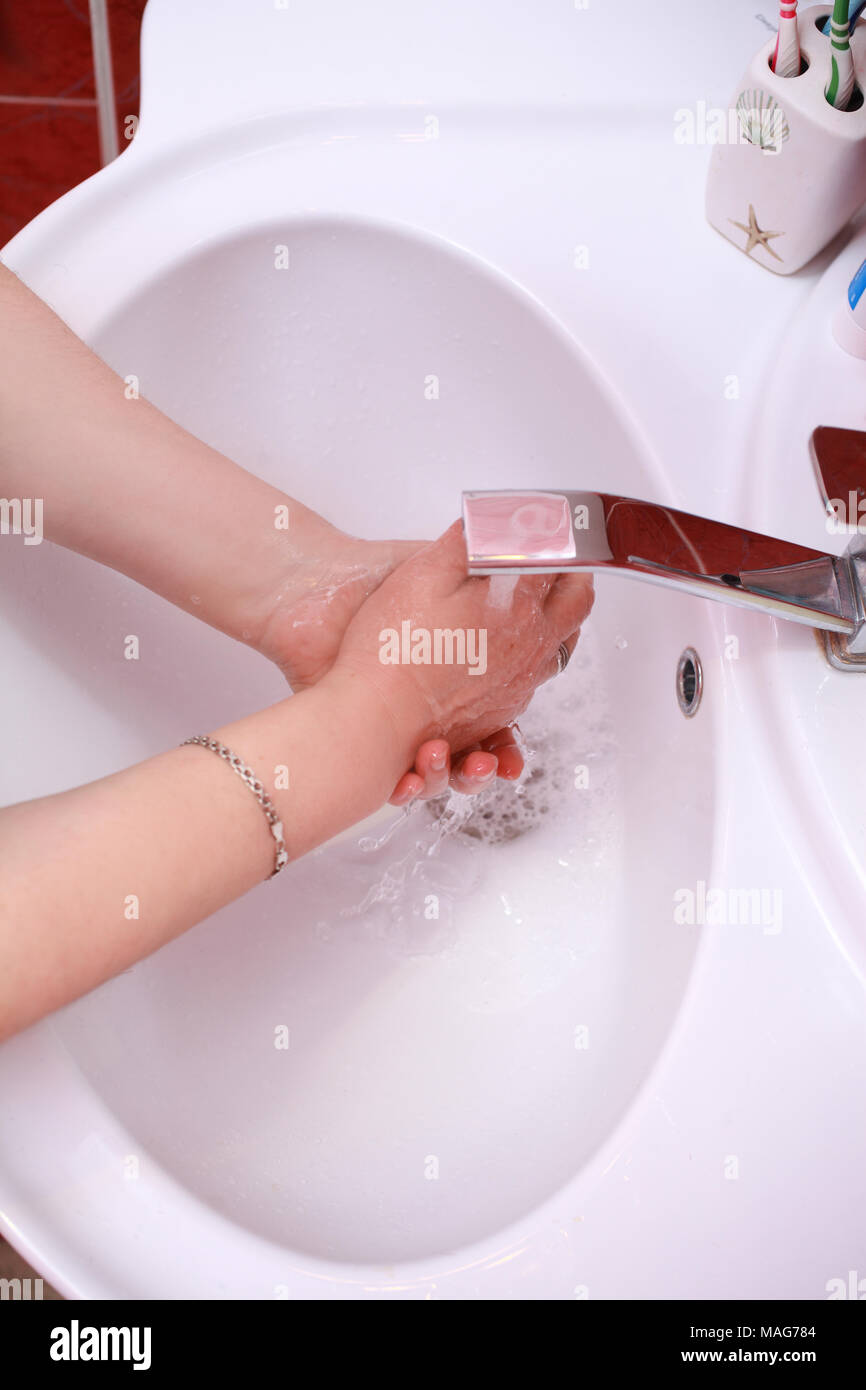 Nella stanza da bagno, una donna lava le mani. Foto Stock