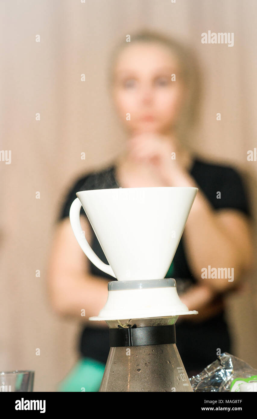 Un pourover, per la preparazione del caffè, con una femmina in background Foto Stock
