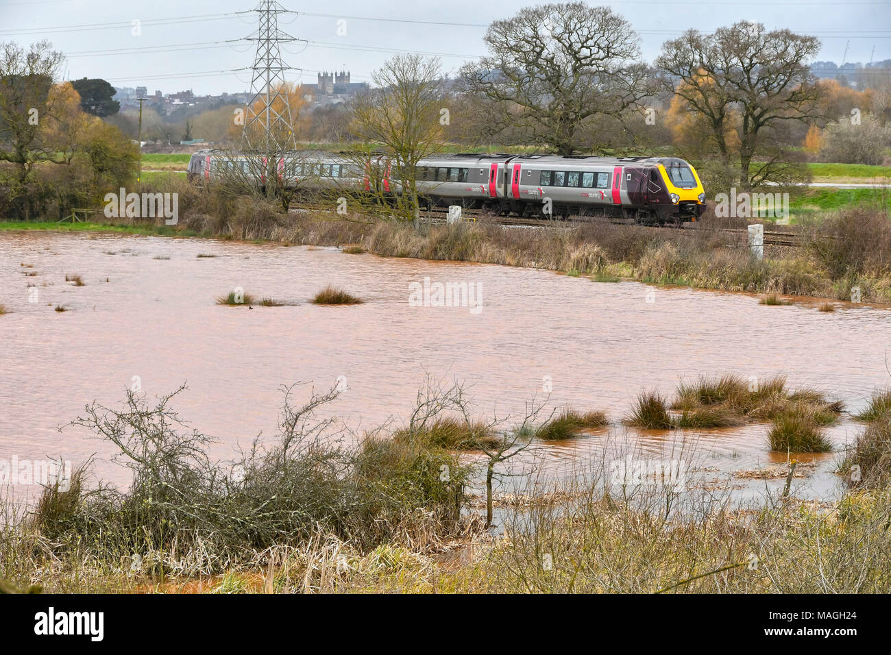 Exeter Devon, Regno Unito. Il 2 aprile 2018. Regno Unito Meteo: un treno sulla Exeter a Plymouth mainline linea ferroviaria passa da un campo inondato a Contessa usura vicino a Exeter in Devon dopo una notte di heavy rain. Credito Foto: Graham Hunt/Alamy Live News Foto Stock