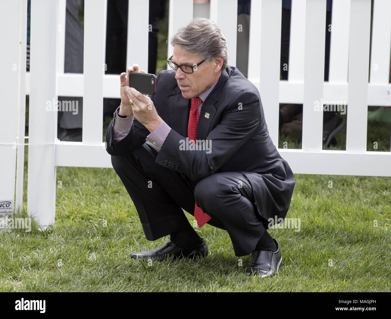 Washington, Distretto di Columbia, Stati Uniti d'America. 2 apr, 2018. Stati Uniti Segretario di energia Rick Perry fotografie di un membro della famiglia che partecipa all'Uovo di Pasqua gara prima di noi Presidente Trump e la first lady Melania Trump rendendo commento all'annuale White House Easter Egg Roll sul prato Sud della Casa Bianca di lunedì, 2 Aprile 2018.Credit: Ron Sachs/CNP Credito: Ron Sachs/CNP/ZUMA filo/Alamy Live News Foto Stock