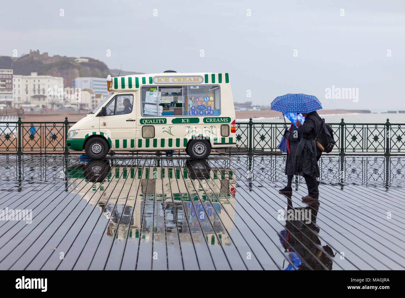 Hastings, East Sussex, Regno Unito. 2 apr, 2018. Bank Holiday UK Meteo: docce, drizzly pioggia nella località balneare di Hastings in questa Pasqua lunedì pomeriggio con un sacco di gente fuori e circa la schermatura stessi con ombrelloni. © Paul Lawrenson 2018, Photo credit: Paolo Lawrenson / Alamy Live News Foto Stock