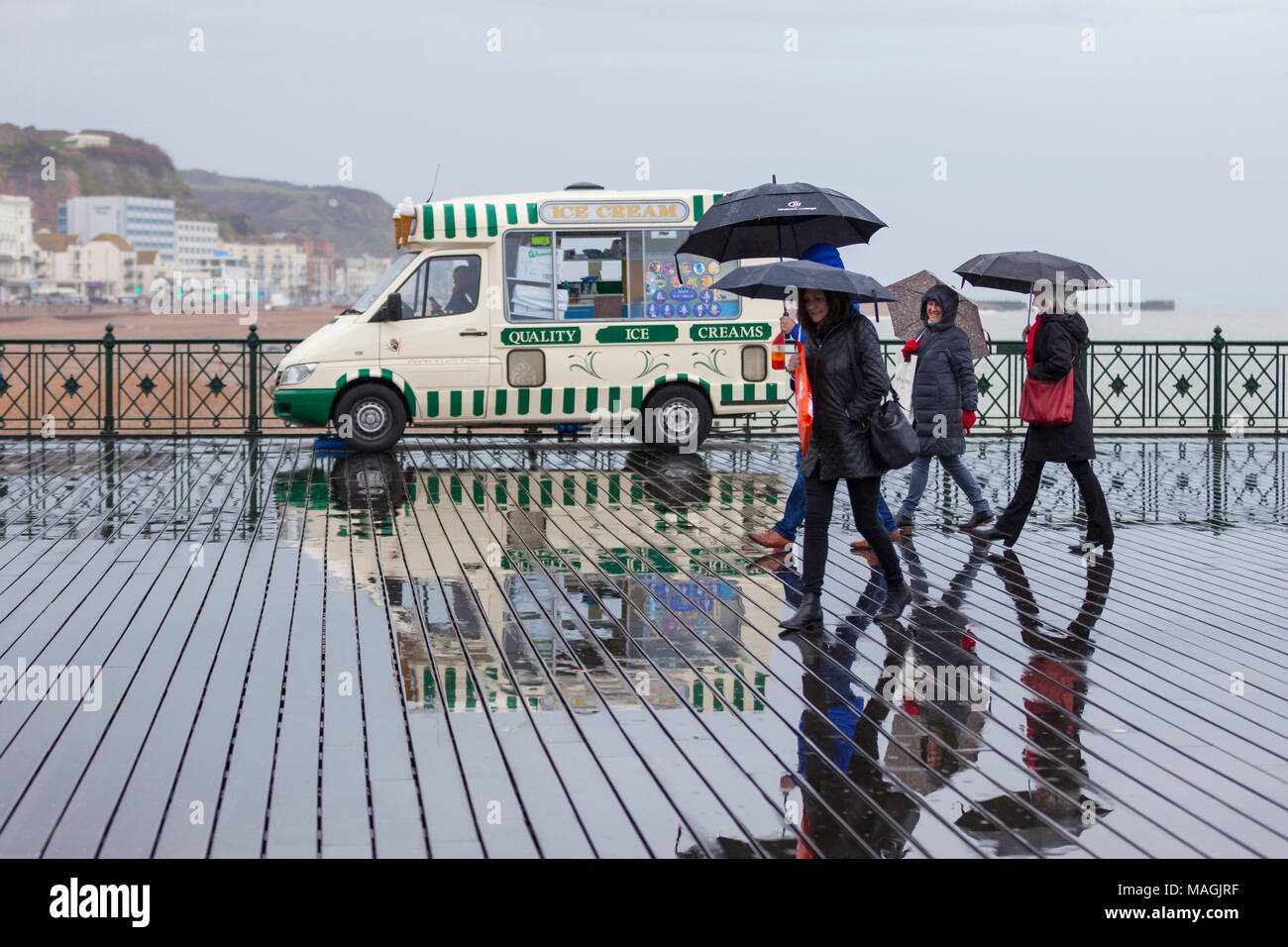 Hastings, East Sussex, Regno Unito. 2 apr, 2018. Bank Holiday UK Meteo: docce, drizzly pioggia nella località balneare di Hastings in questa Pasqua lunedì pomeriggio con un sacco di gente fuori e circa la schermatura stessi con ombrelloni. © Paul Lawrenson 2018, Photo credit: Paolo Lawrenson / Alamy Live News Foto Stock