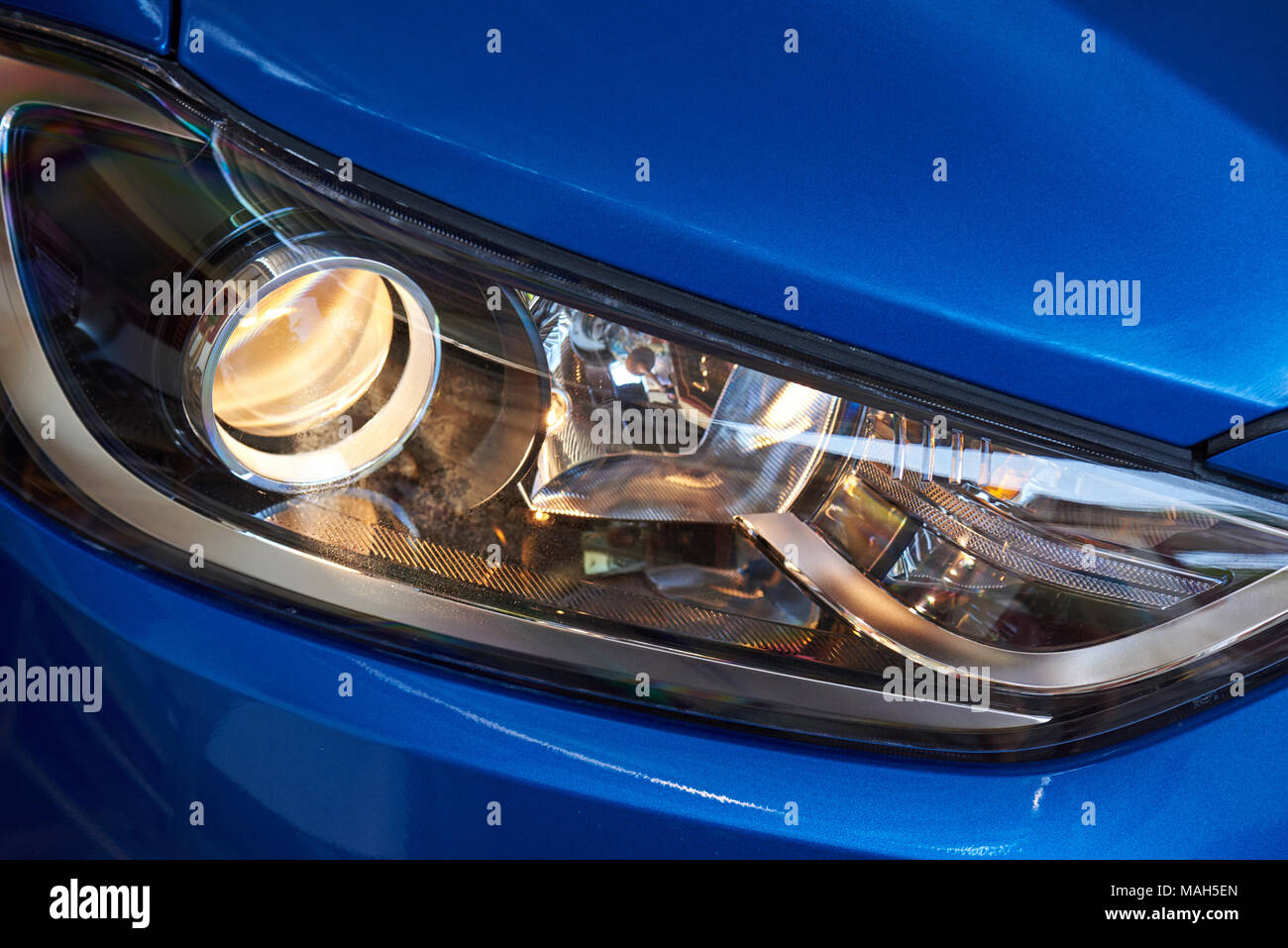 Primo piano della testa sulla luce blu sport moderno auto. Giallo luce dal LED ottica auto Foto Stock