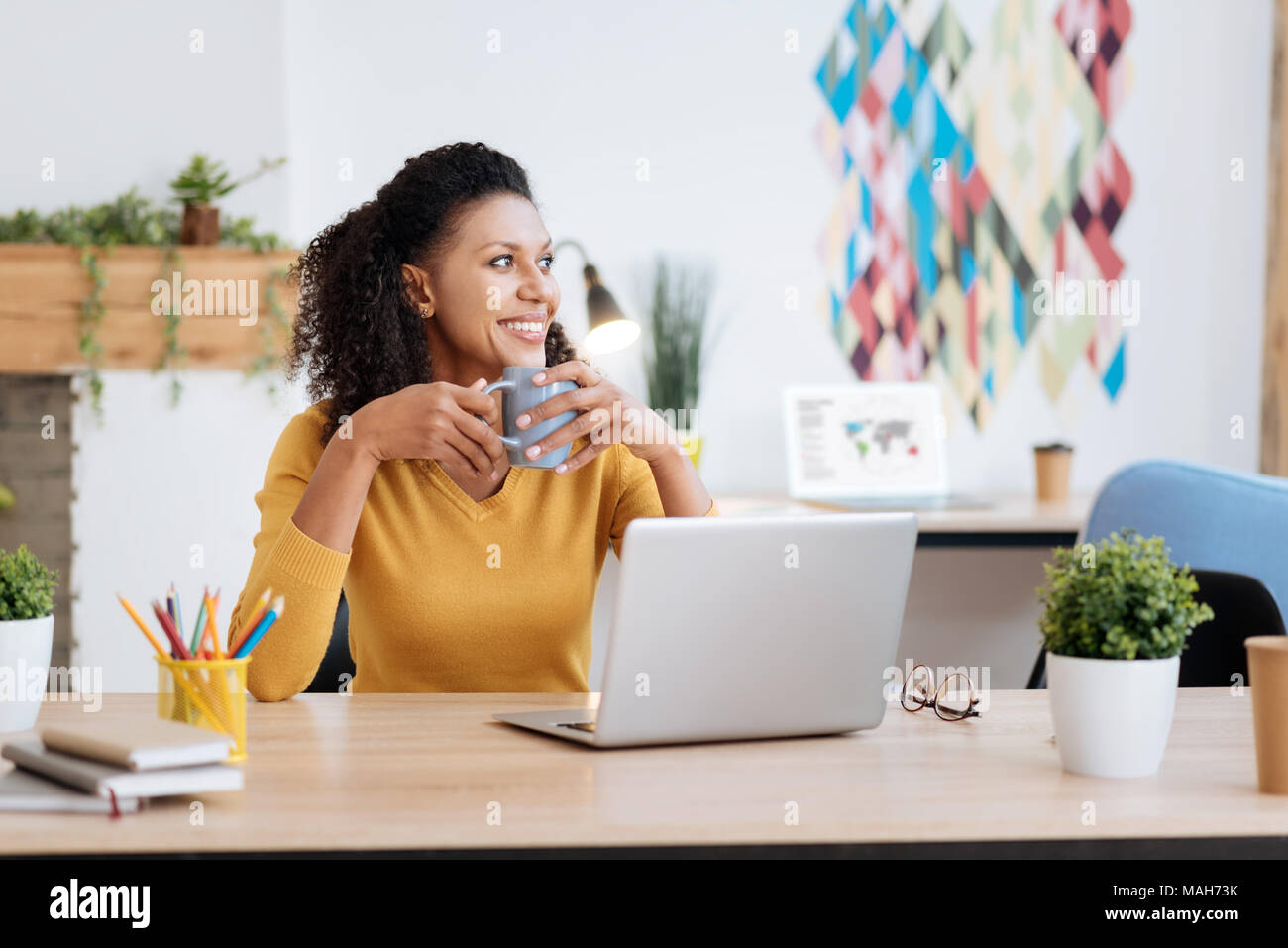 Alert freelancer sorridente e bere il tè Foto Stock