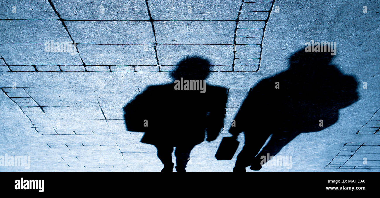 Silhouette ombre di due persone in viaggio a piedi su via della città di notte Foto Stock