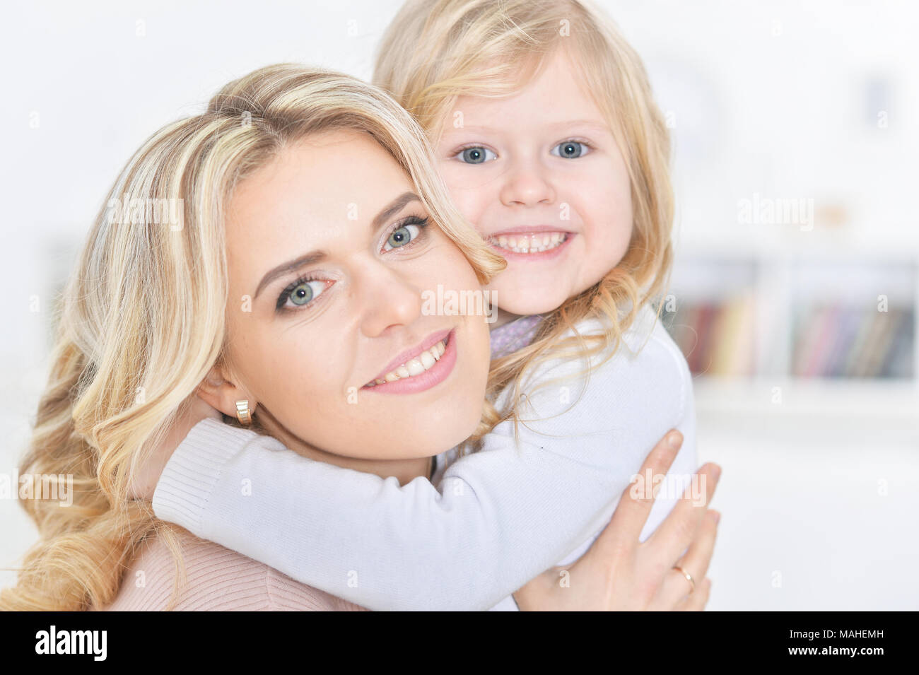 Felice Giovane Donna con bambina abbracciare Foto Stock