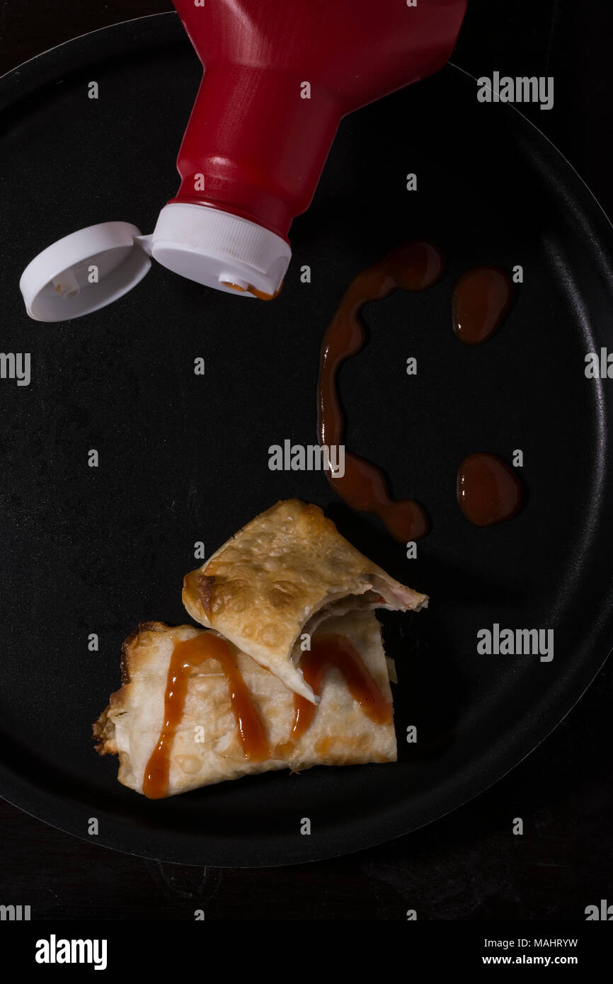 Bottiglia di ketchup con samosa sul vassoio con salsa rossa su di esso, vista dall'alto Foto Stock
