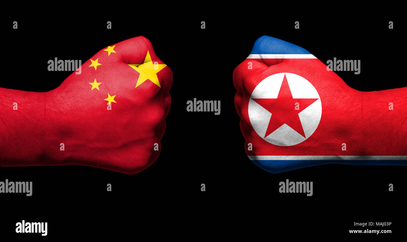 Bandiere di Cina e Corea del Nord dipinta su due pugni rinserrata affacciati su sfondo nero/Cina e Corea del Nord il concetto di relazione Foto Stock