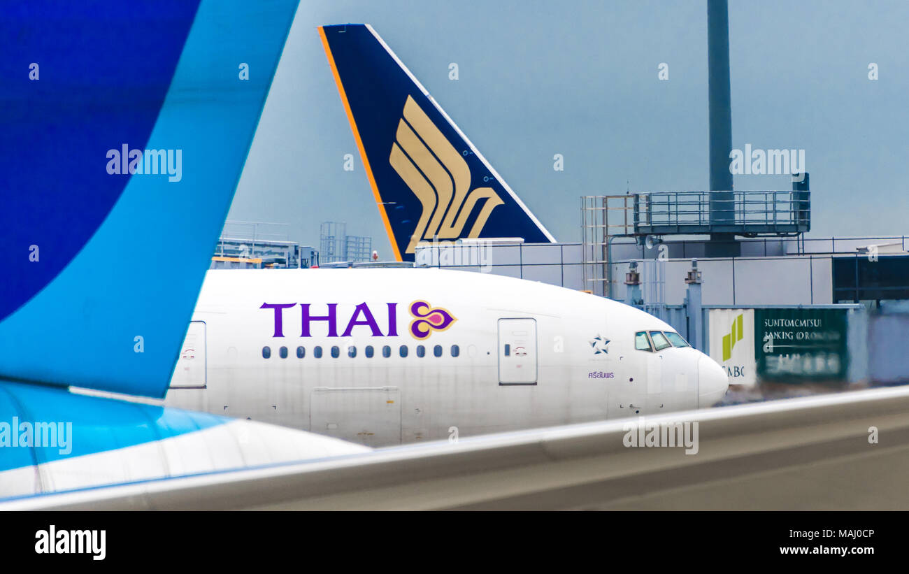 Due jetliner tails incornicia un Thai Airways jetliner Foto Stock