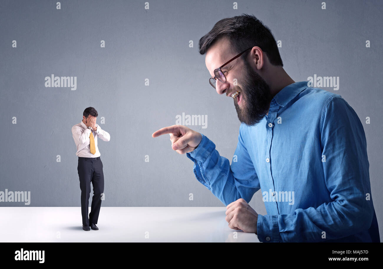 Giovane imprenditore professionale essendo arrabbiato con un altro imprenditore in miniatura Foto Stock