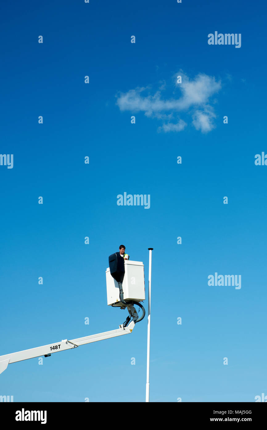 Un palo di bandiera vuoto e un operaio su un ascensore picker che rimuove una bandiera dopo la Brexit - nessuna bandiera - bandiera rimossa Foto Stock