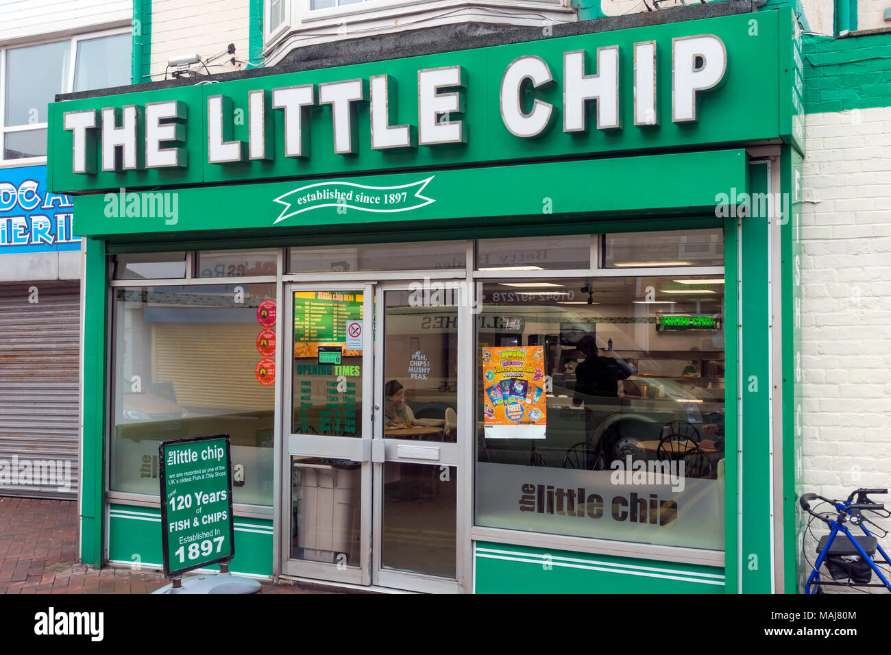 Il piccolo chip pesce e Chip shop in Redcar North Yorkshire istituito nel 1897 uno dei più antichi in Inghilterra con una mobilità con un Rollator al di fuori Foto Stock