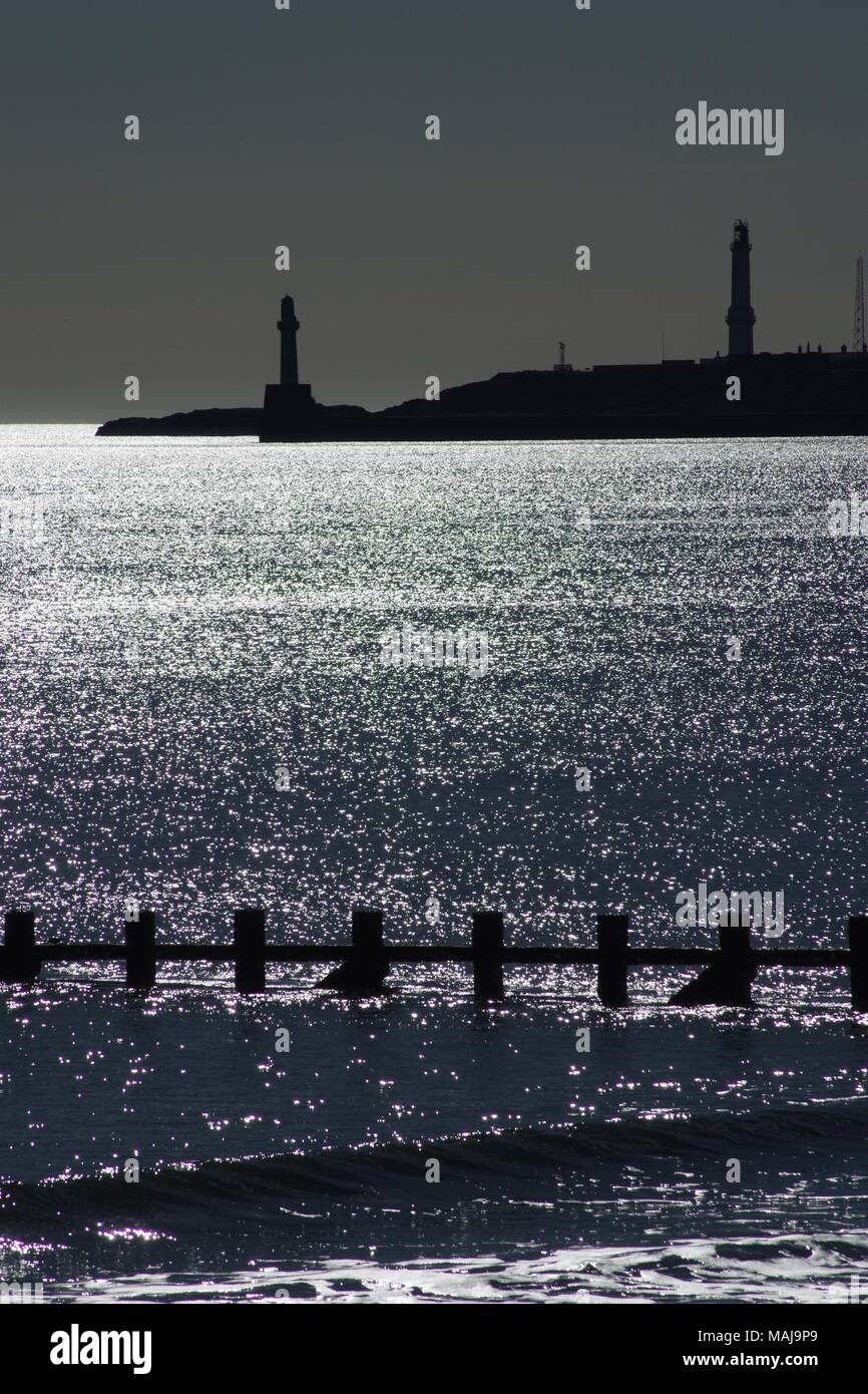Faro Girdleness al di là di una tranquilla scintillanti del mare del Nord. Aberdeen, Scozia, Regno Unito. Foto Stock