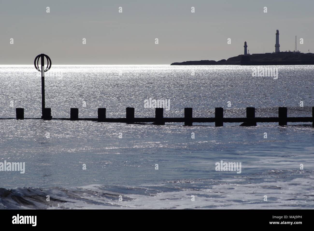 Faro Girdleness al di là di una tranquilla scintillanti del mare del Nord. Aberdeen, Scozia, Regno Unito. Foto Stock