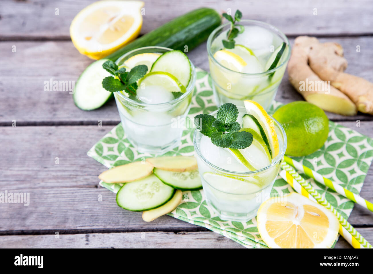 Limonata fatta in casa con calce, menta, lo zenzero, il cetriolo e il ghiaccio su un sfondo di legno. Foto Stock