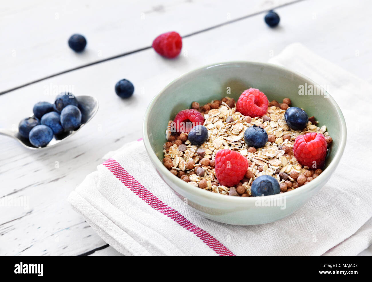 Cereali in una ciotola, scena prima colazione con frutta fresca e muesli, mangiare sano. Tazza colazione su un tavolo di legno rustico, scena. Foto Stock