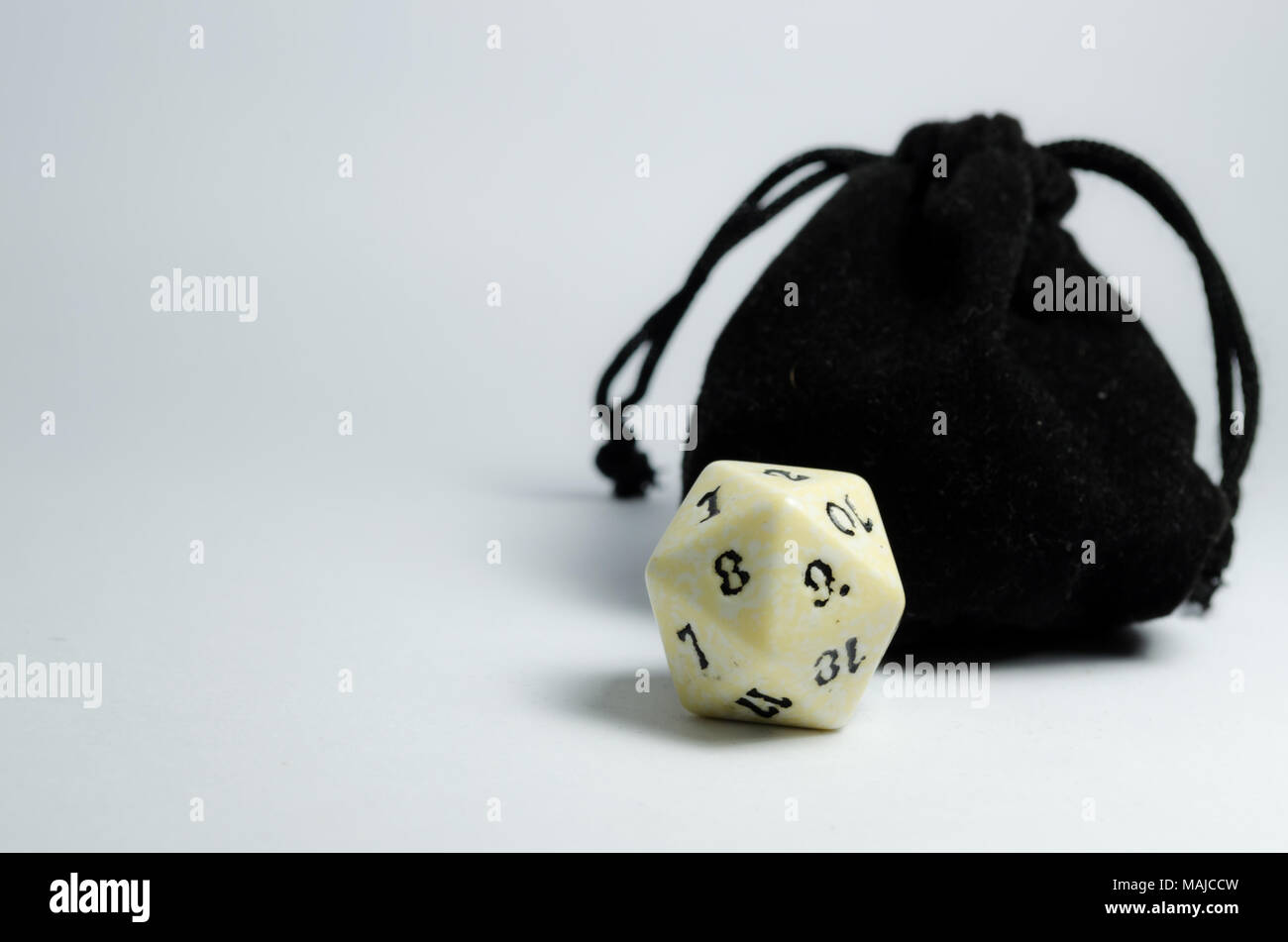 White venti facciate dadi e una piccola borsa nero su uno sfondo bianco. Dadi del gioco di ruolo e Dungeons and Dragons. Foto Stock