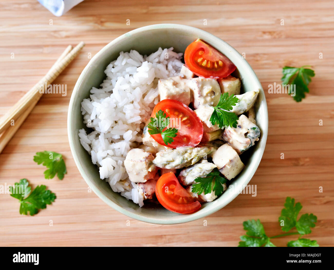 Delizioso piatto di tofu con pomodori freschi e prezzemolo in una ciotola. Piatto di riso, cibo vegan o vegetariano. Foto Stock