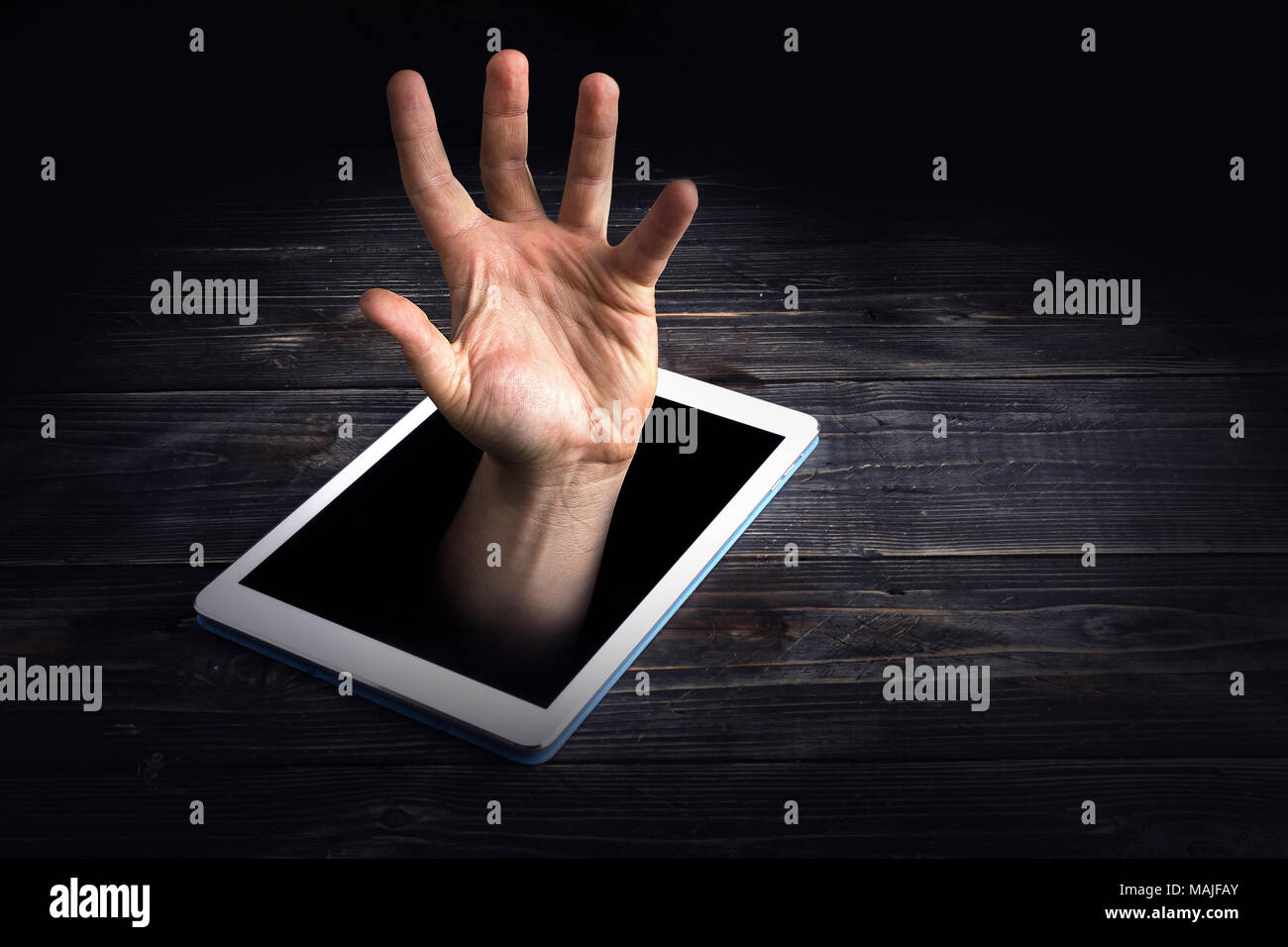 Smart phone addiction concetto su sfondo rosso. mano è affondata nella schermata. Foto Stock