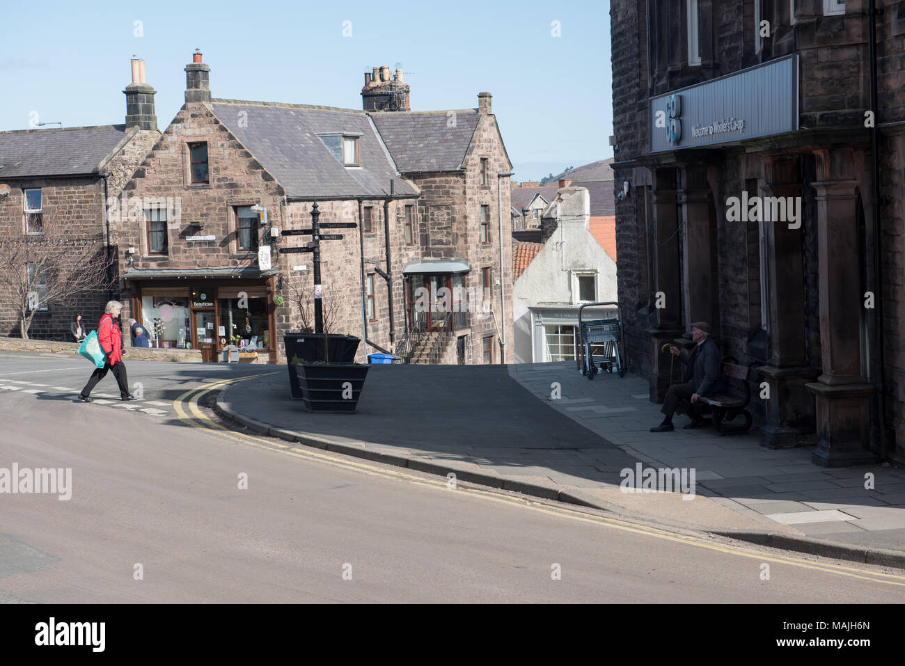 Scena di strada nel villaggio di Holy Island, Lindisfarne, Northumberland, Inghilterra, che mostra edifici storici in pietra e la vita quotidiana locale Foto Stock