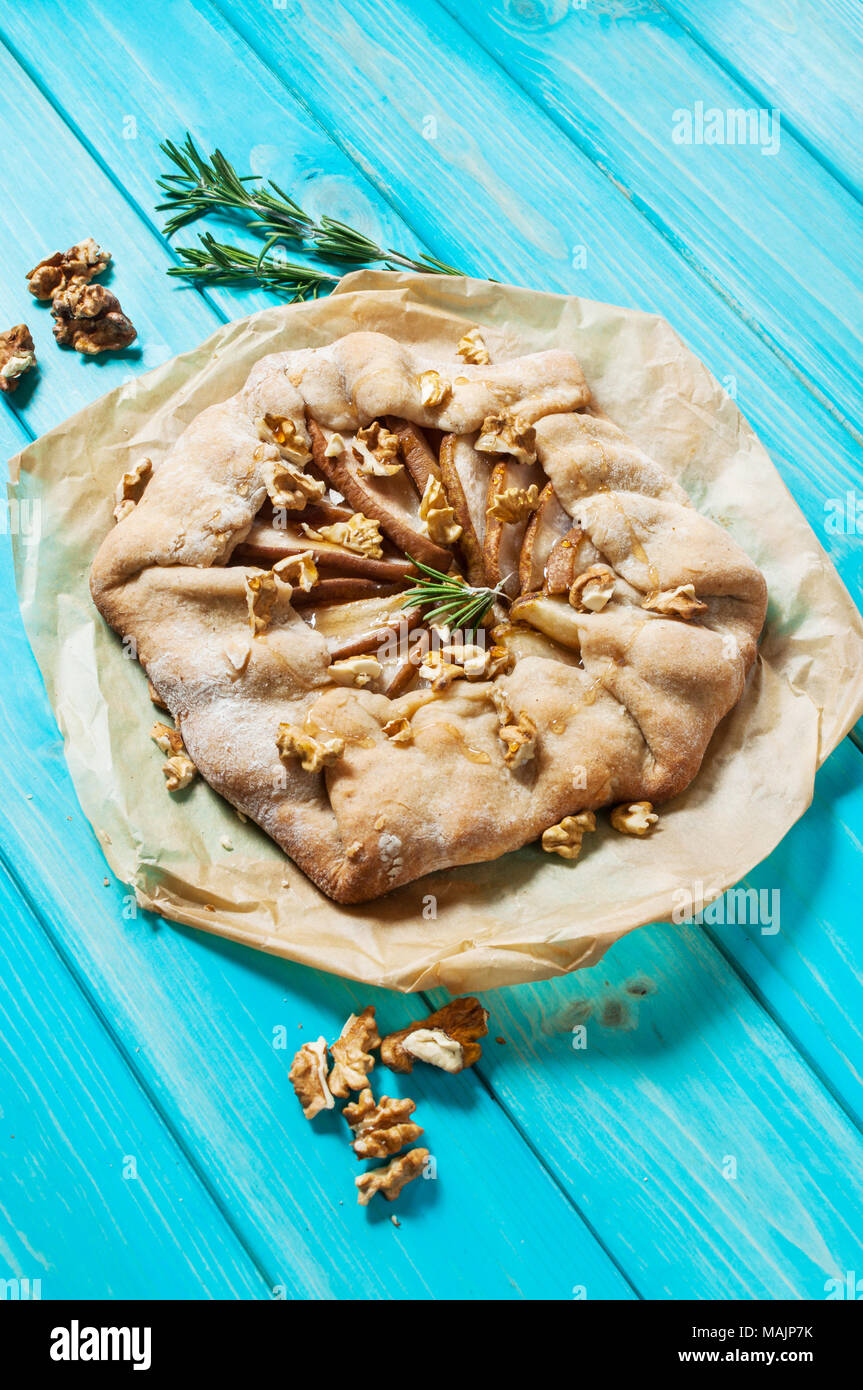 Torte fatte in casa con pere e noci in blu sullo sfondo di legno. Foto Stock