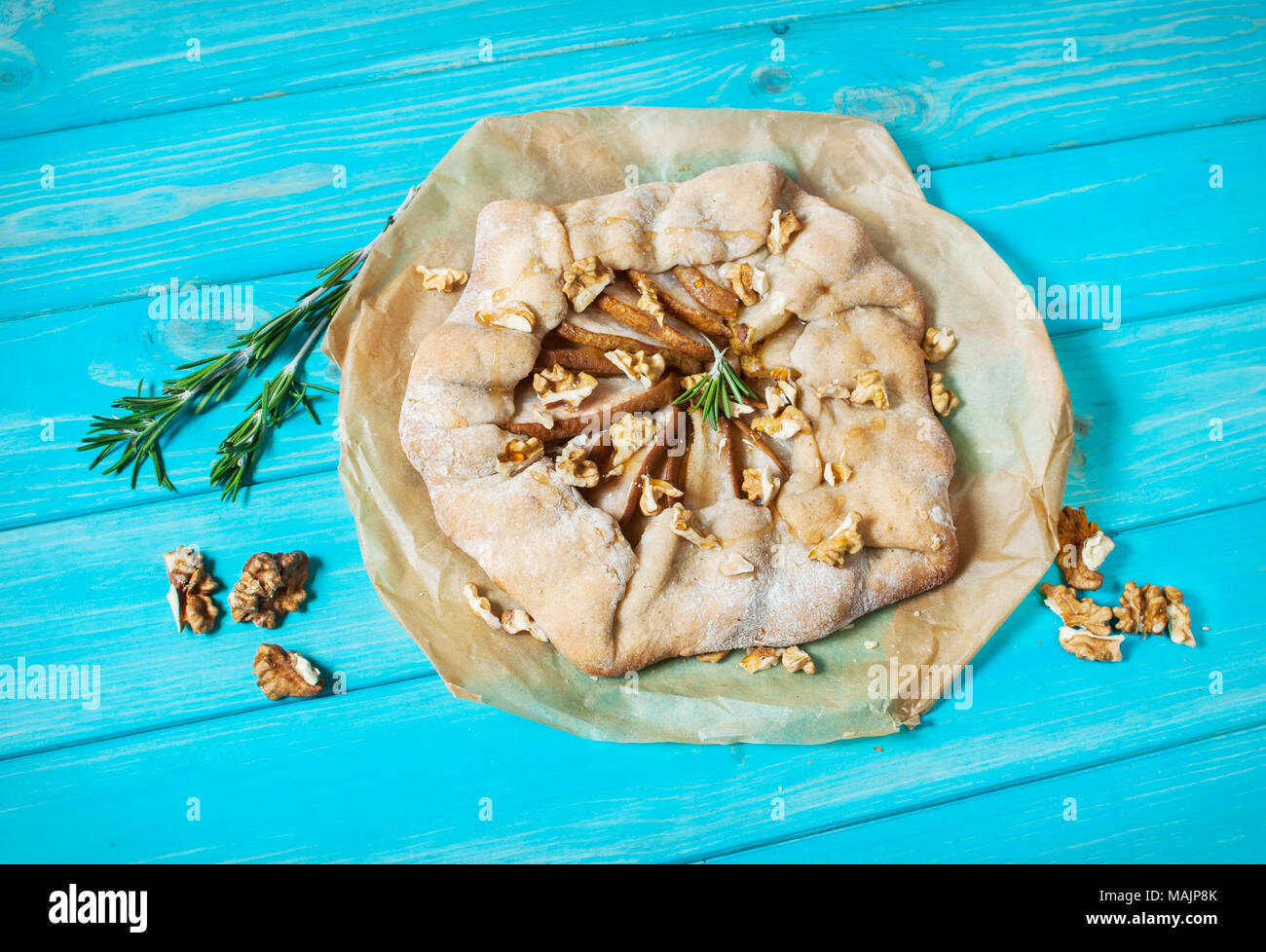 Torte fatte in casa con pere e noci in blu sullo sfondo di legno. Foto Stock