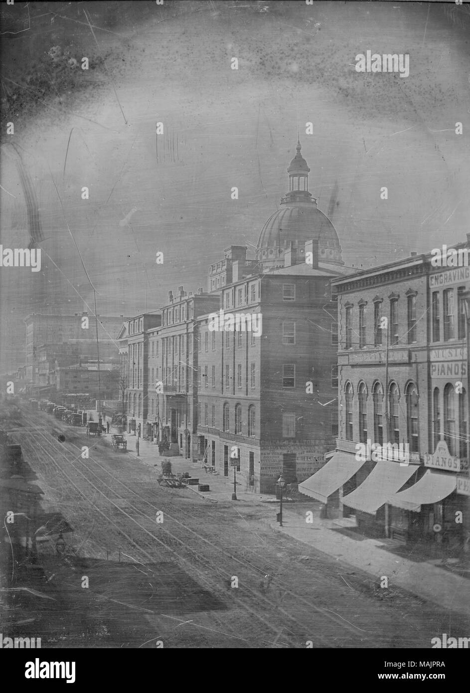 Una vista della quarta strada, guardando a sud da Olive Street. Una grande cupola-edificio possono essere visti sullo sfondo di una linea di edifici commerciali verso il basso Fourth Street. Una struttura viene contrassegnato con un segno di fronte ad esso che si legge 'Ticket Office 49' e ha un paio di schede e casse prima sul marciapiede. Annunci pubblicitari sulle sue pareti indica che esso è il 'Chicago e Alton Biglietteria' e che offrono un 'Direct" la strada a Chicago e viaggi a New York, Boston, Pittsburg, Philadelphia, Detroit, Cleveland, e le Cascate del Niagara. Molti cavalli e carrozze lungo le strade, nonché un paio di pe Foto Stock