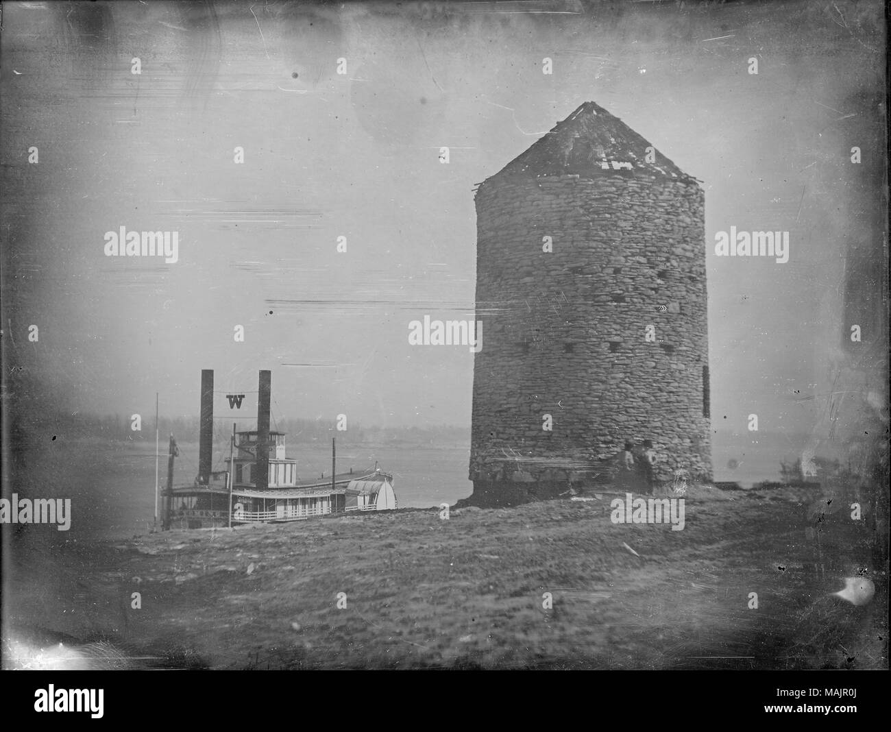 Due ragazzi di stare di fronte alla vecchia fortezza spagnola, più tardi Roy's Mill, sul lungofiume ai piedi di Biddle Street. Il sistema di cottura a vapore del Wyoming è presso la banca di fiume. Al momento di questa fotografia, questa struttura è stato segnalato per essere l'unico superstite superstiti della spagnola fortificazioni intorno a San Louis. Sebbene sia stato costruito durante il periodo spagnolo, la torre che è venuto a essere conosciuta come la vecchia fortezza spagnola è stata in realtà costruita nel 1797 da Antoine Roy come un vento powered gristmill. È gestito come un mulino fino al 1810, e ha agito come il primo confine nord della città di St. Louis. Fu demolita nel 1856 per Foto Stock