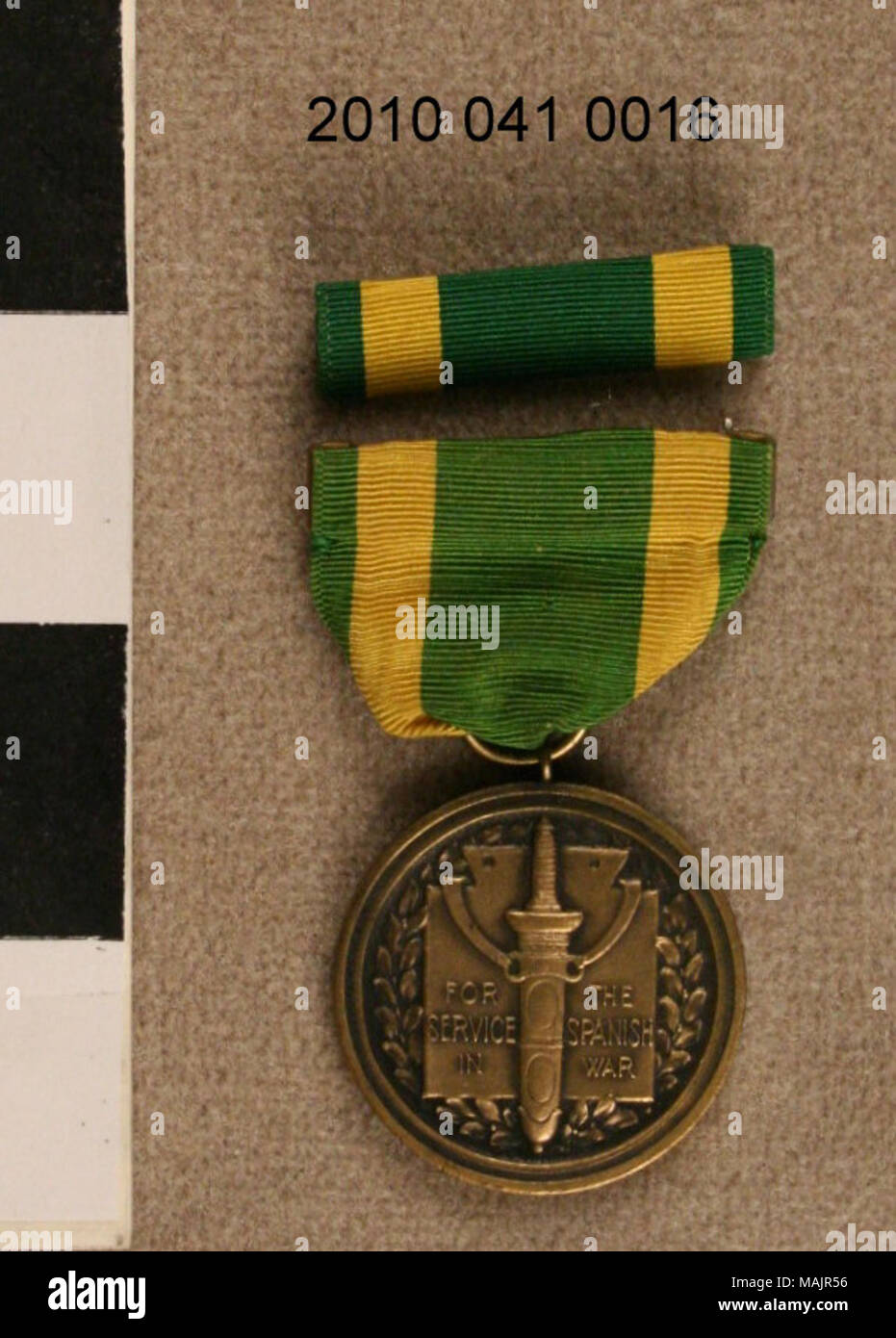 Medaglia commemorativa guerra ispano-americana. Panno verde con strisce gialle con medaglione in metallo a penzoloni raffigurante una spada e motivo di foglie. Retro mostra eagle e motivo di armi. Spina della barra è di colore verde con strisce gialle. Titolo: guerra spagnola medaglia di servizio Bar e il perno . 1898. Foto Stock