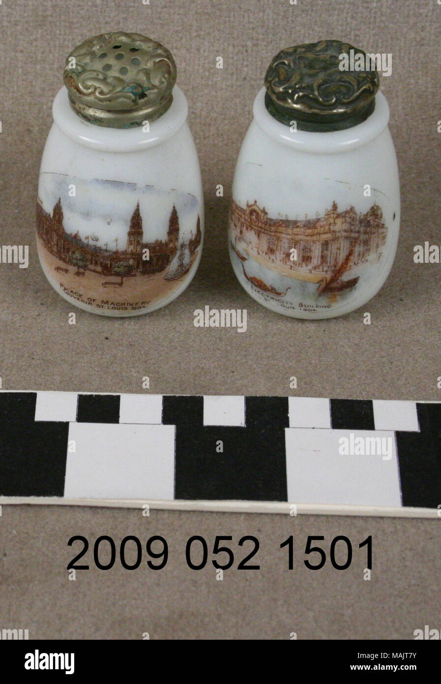 Coppia di bicchiere di latte sale e pepe hanno ornato cime di ottone e trasferimenti di colore del palazzo di elettricità su uno e il palazzo di macchinari dall'altro. Queste sono souvenir dal 1904 della fiera del mondo. Titolo: bicchiere di latte sale e pepe con trasferimenti di colore del palazzo di elettricità e Palazzo di macchinari . 1904. Foto Stock