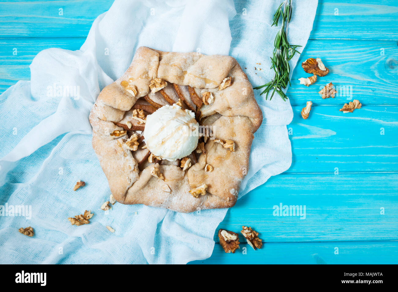 Torte fatte in casa con pere e gelati su blu sullo sfondo di legno. Foto Stock