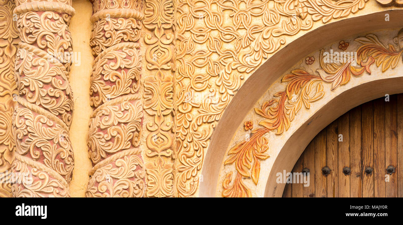 Chiesa ornata architettura con porta di legno in America Latina in stile barocco come sfondo a trama Foto Stock