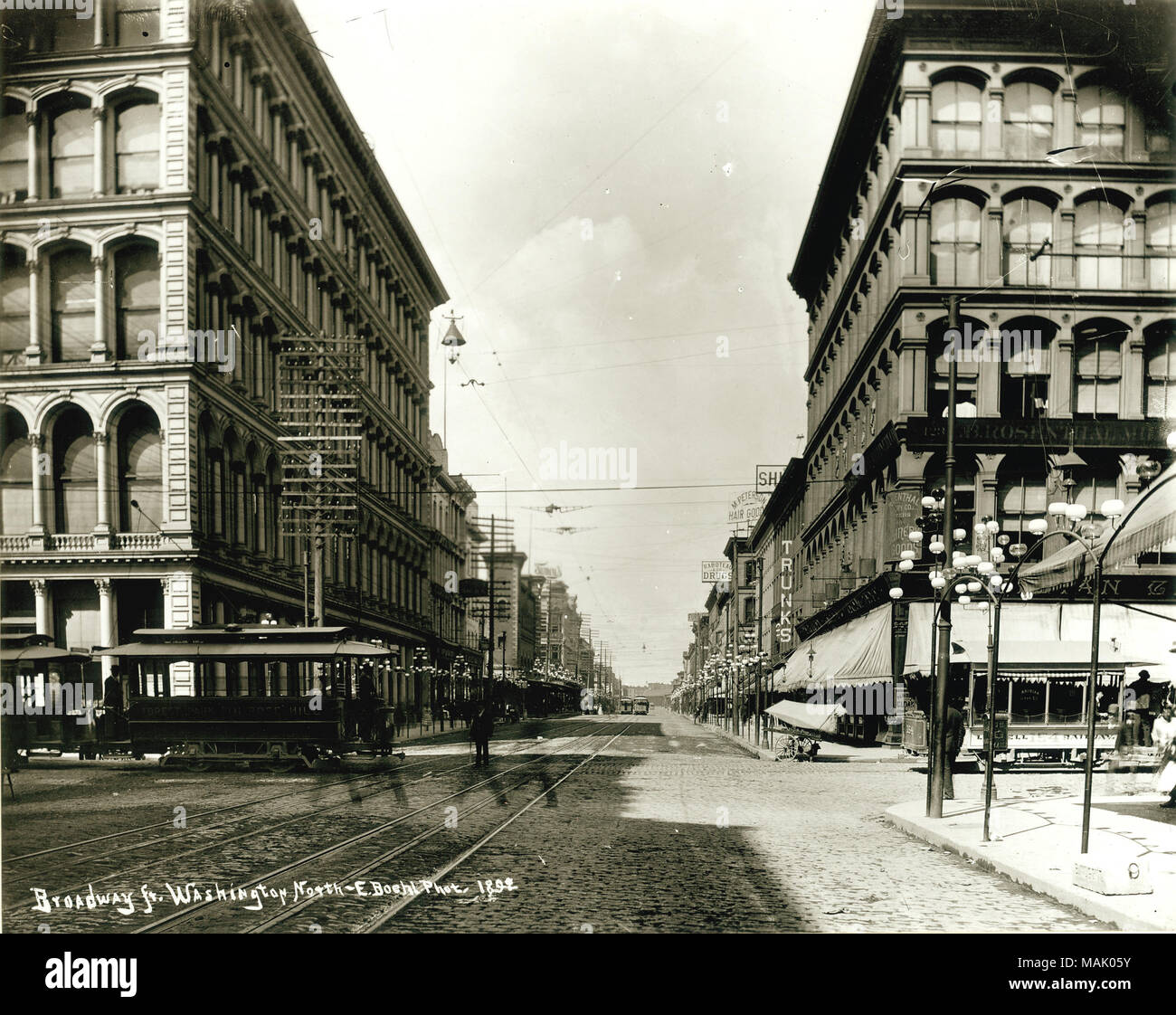 Vista guardando a nord su Broadway da Washington Avenue. Un quartiere commerciale comprese nei negozi al dettaglio e la Raboteau e Co. La droga a 714 North Broadway sono visibili. Manto parigino Azienda e I.B. Rosenthal Millinery Co. si trovano all'angolo nord-est dell'intersezione. Titolo: vista guardando a nord su Broadway da Washington Avenue. . 1892. Emil F. BUHL Foto Stock