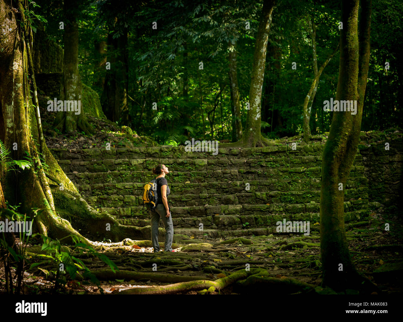 Femmina da solista traveler in antiche rovine di foresta Foto Stock