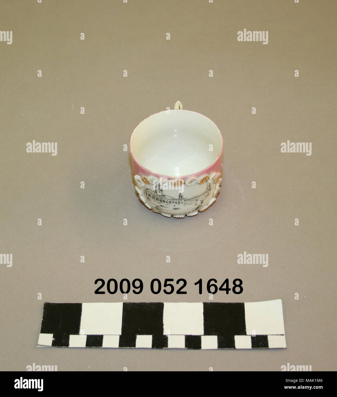 Bianco di ceramica tazzina, colorato di rosa, ha gilt d+?cor e un nero immagine di trasferimento dei macchinari edificio dal 1904 della fiera del mondo. Titolo: bianco di ceramica tazzina, colorato di rosa, nero con immagine di trasferimento dei macchinari edificio . 1904. Foto Stock