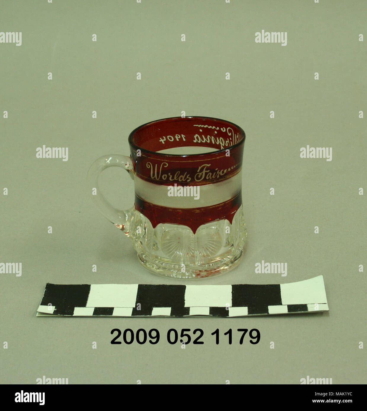 Ruby colorate mug ha premuto bloccato identificazione personale modello di banda, banda smerigliato attraverso la sezione di rubino e viene personalizzato a Virginia. Si tratta di un negozio di souvenir dal 1904 della fiera del mondo. Titolo: Ruby colorate la tazza con il blocco di identificazione personale modello di banda personalizzata al Virginia . 1904. Foto Stock