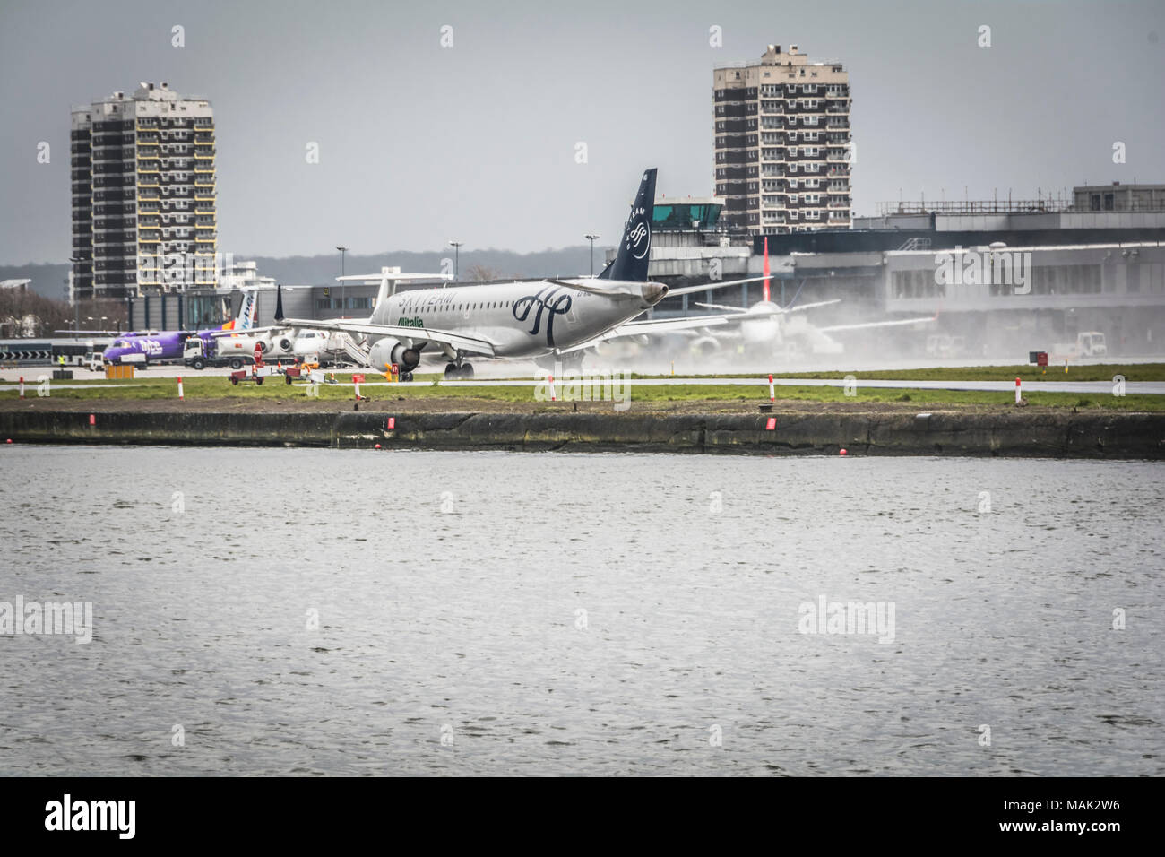 Un Skyteam Alitalia Embraer 190 jet in atterraggio a London City Airport, un international business airport in London Borough of Newham, London, Regno Unito Foto Stock