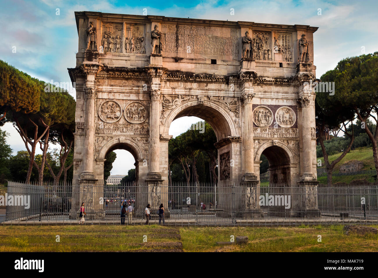 L'Arco di Costantino nel Forum, Roma, fiancheggiata da Roma simbolico del pini larici, è il romano più grande arco trionfale Foto Stock