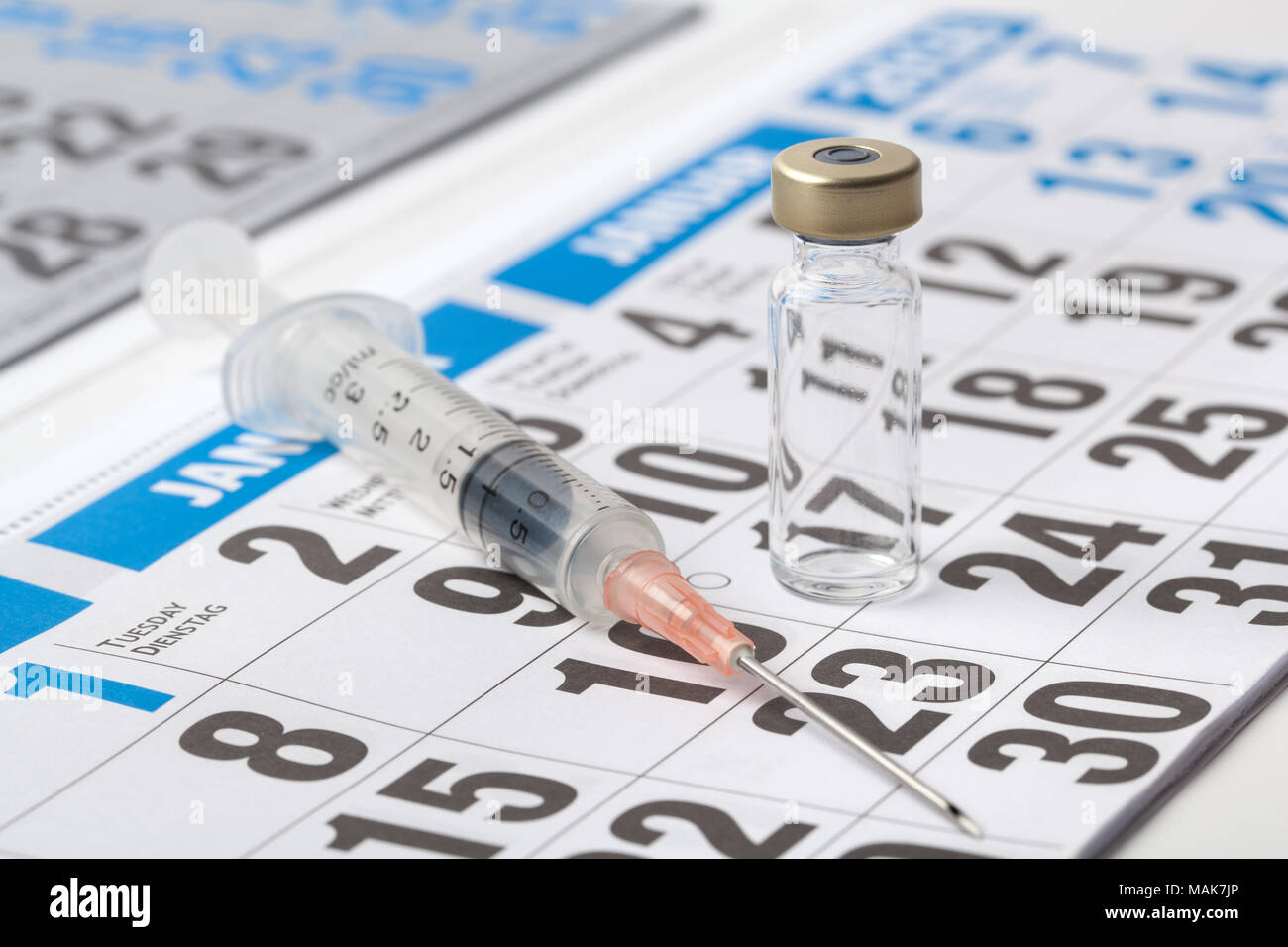 Flaconcino trasparente fiala di un vaccino e la siringa su un foglio del diario Foto Stock