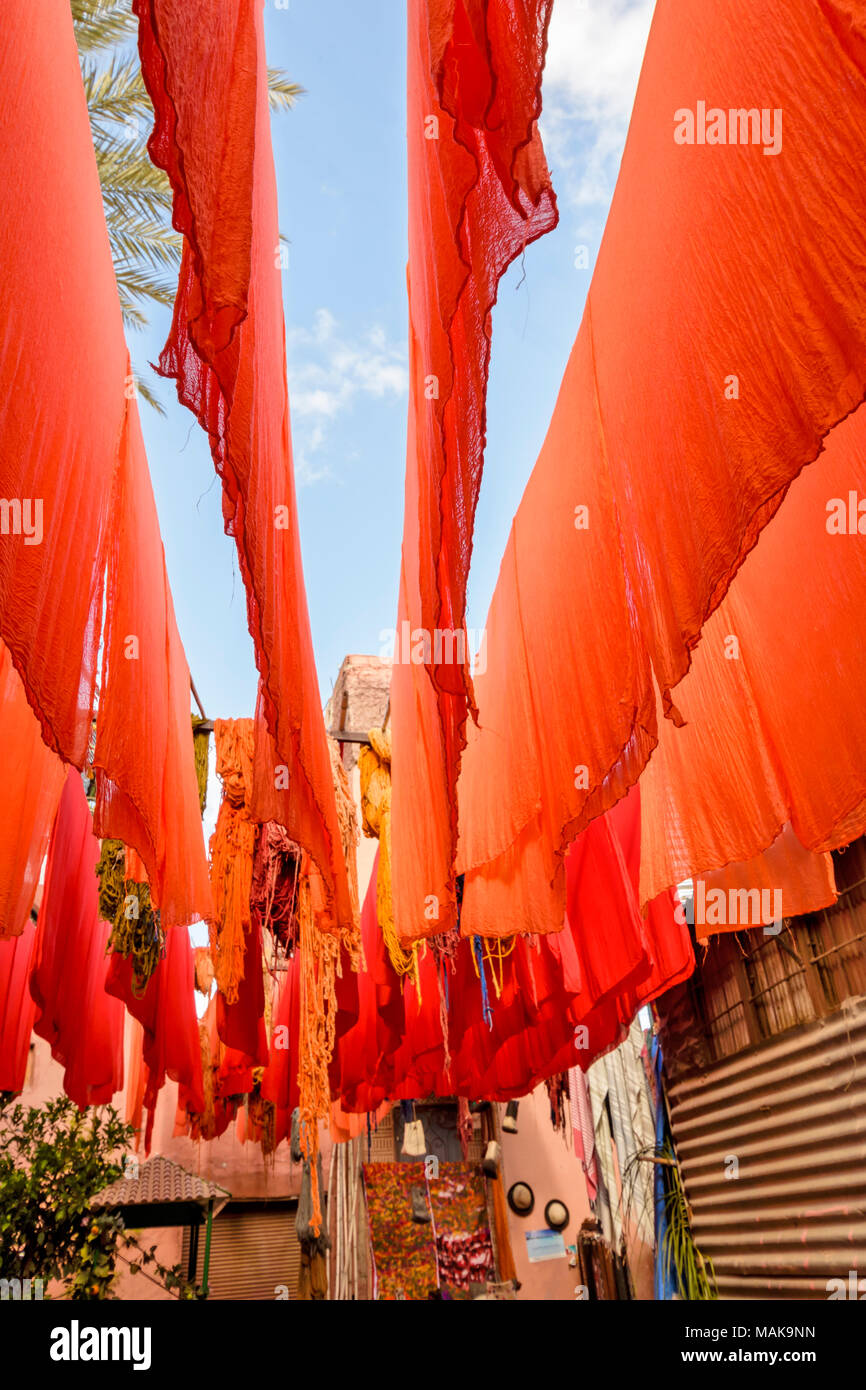 Il Marocco Marrakech Jemaa el Fna MEDINA SOUK ORANGE panno tinto appesi da poli di bambù per asciugare al sole Foto Stock