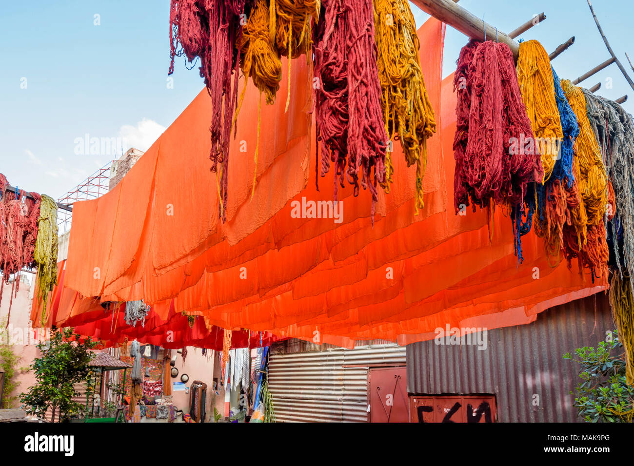 Il Marocco Marrakech Jemaa el Fna SOUK MEDINA un cantiere con multicolore lana tinta arancione e fogli appesi da pali ad asciugare al sole Foto Stock