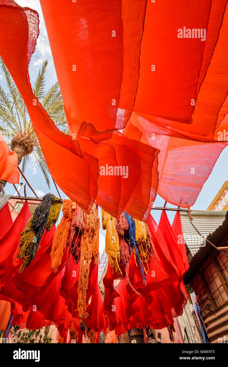 Il Marocco Marrakech Jemaa el Fna MEDINA SOUK IN ROSSO E ARANCIONE fogli tinti e lana multicolore appesi da poli di bambù per asciugare al sole Foto Stock