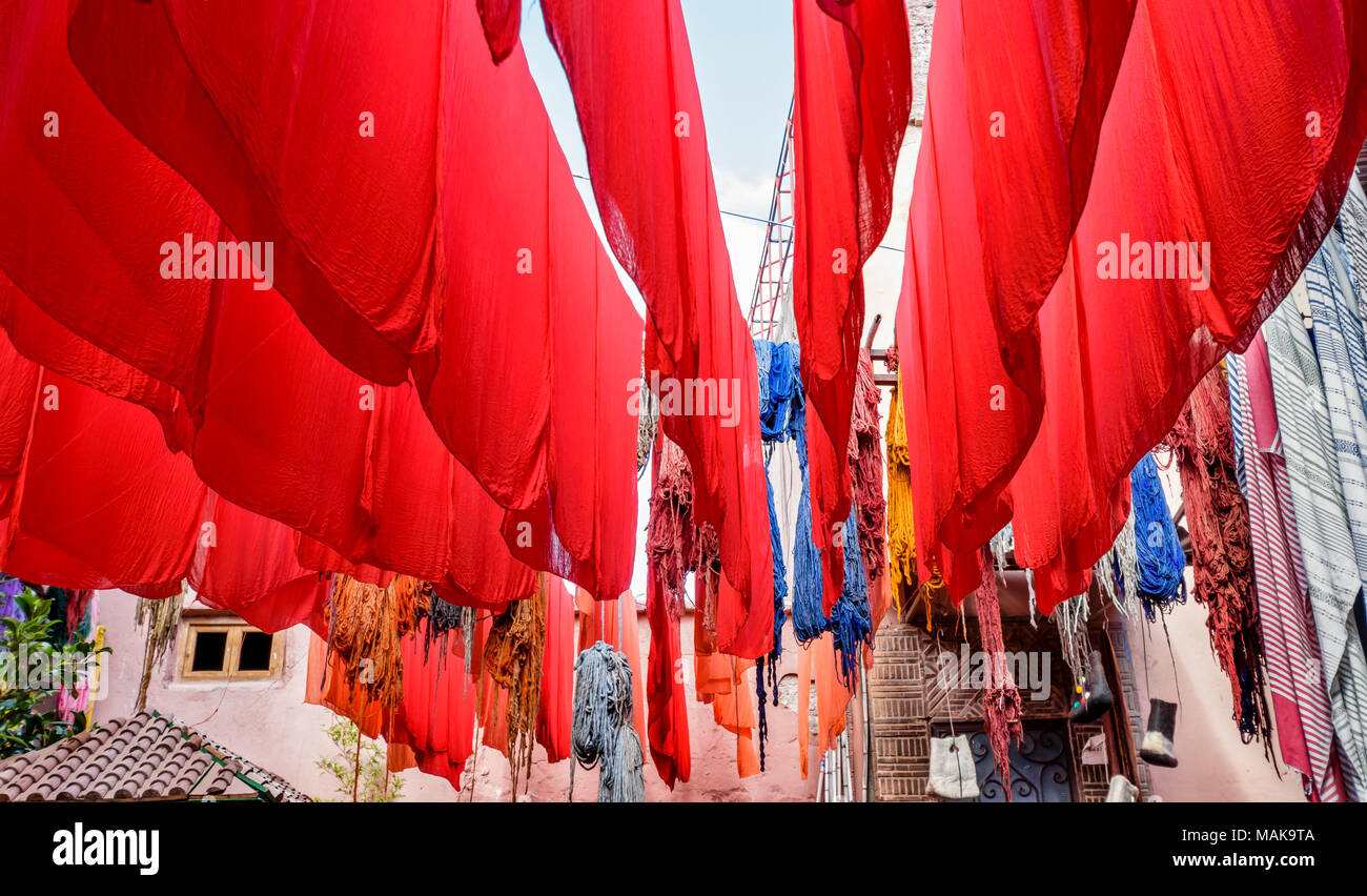 Il Marocco Marrakech Jemaa el Fna MEDINA SOUK RED panno tinto e fogli di lana multicolore appesi da poli di bambù per asciugare al sole Foto Stock
