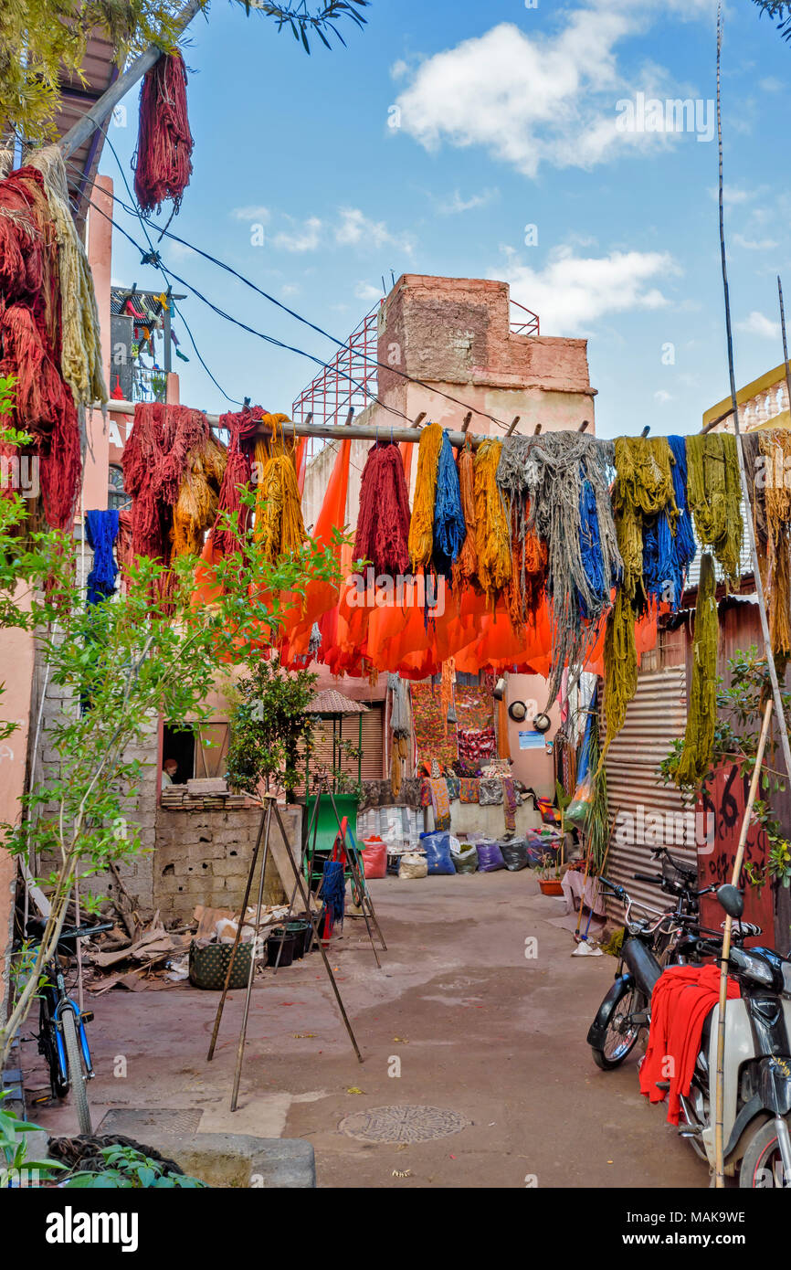 Il Marocco Marrakech Jemaa el Fna MEDINA SOUK cortile con multicolore lana tinta arancione e fogli appesi da pali ad asciugare al sole Foto Stock