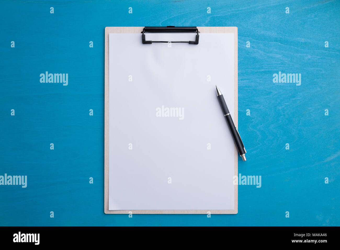 Formato A4 con appunti copia vuota spazio carta e penna blu sulla tavola di legno nel luogo di lavoro. lo sfondo con la zona vuota per il testo o messaggio. Foto Stock