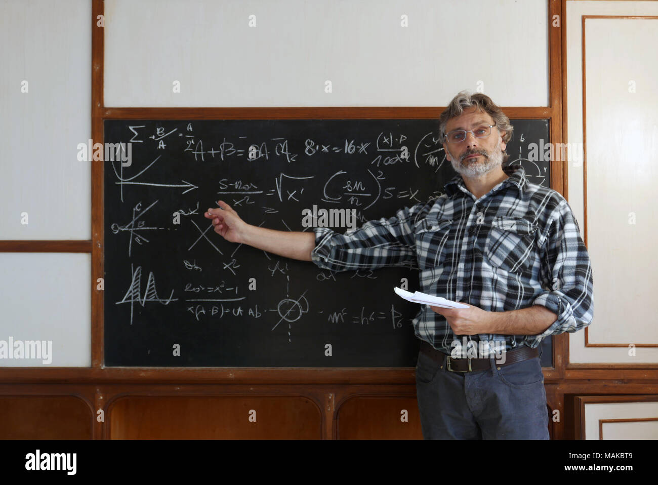 Docente presso l'università conduce la lezione, formule sulla lavagna Foto Stock